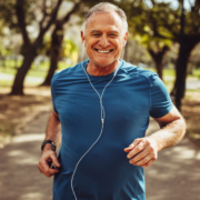 A man running in the park wearing headphones.